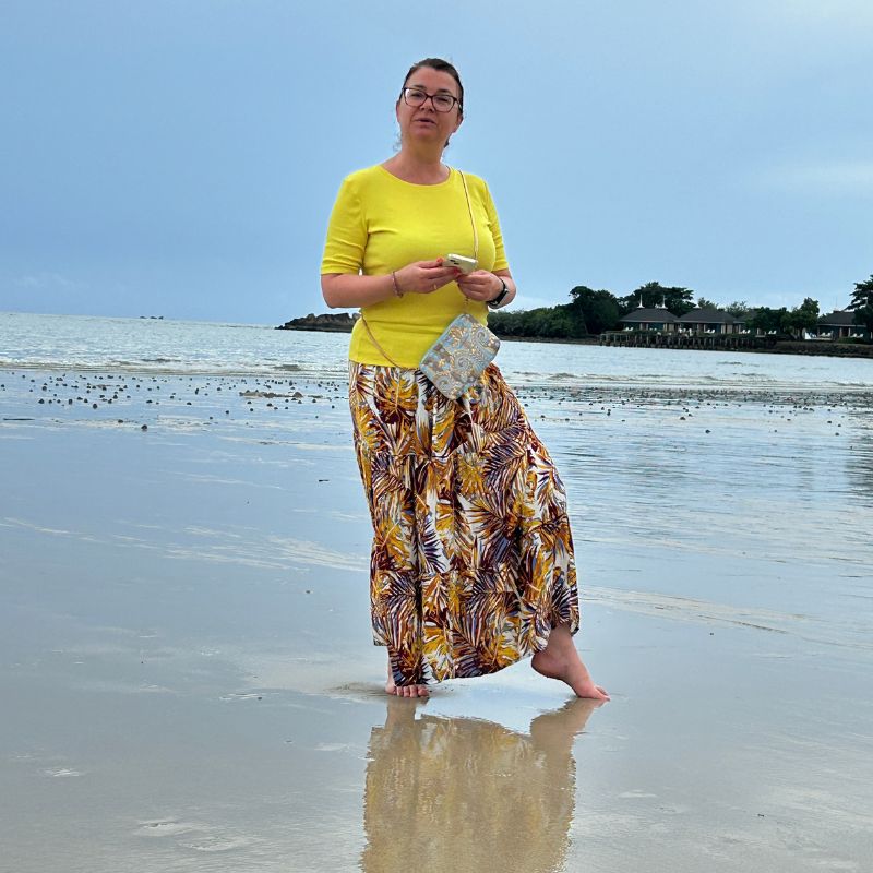 Woman standing in the sea wearing Harmony shoulder bag with EMF protection